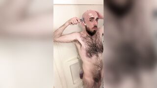 Very hairy skinny blue-eyed white guy shaves his head in the showet